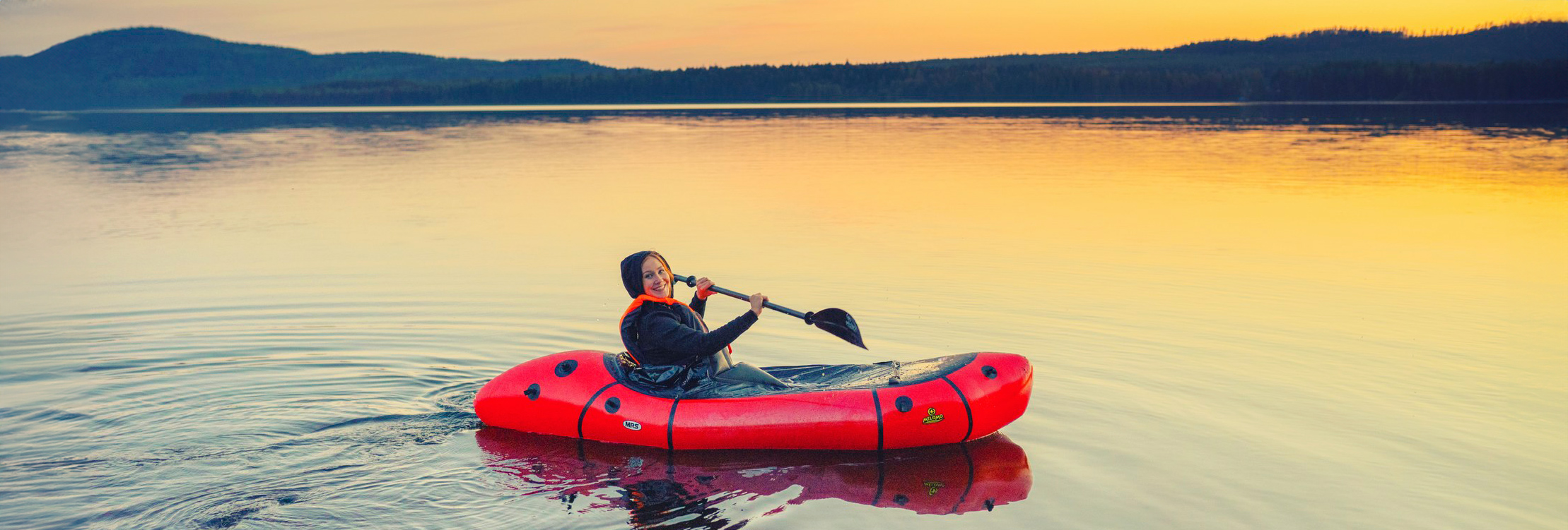 A woman paddling on an inflatable canoe in Lake Pielinen.